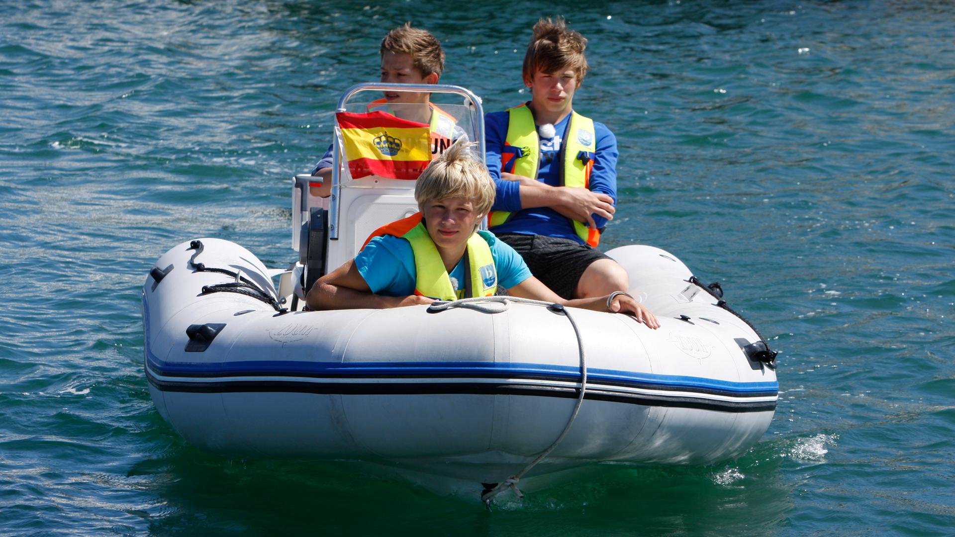 Charlie, Danny und Alex fahren Motorboot.
