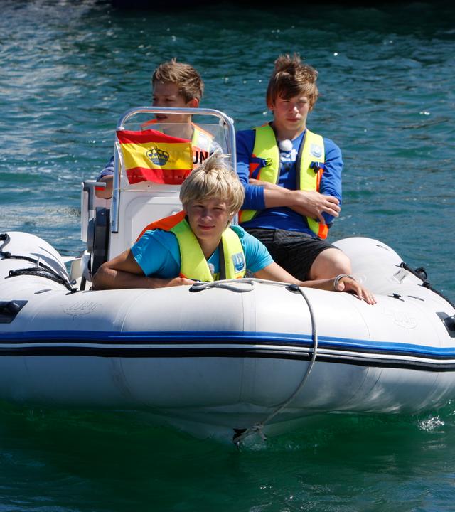 Charlie, Danny und Alex fahren Motorboot.