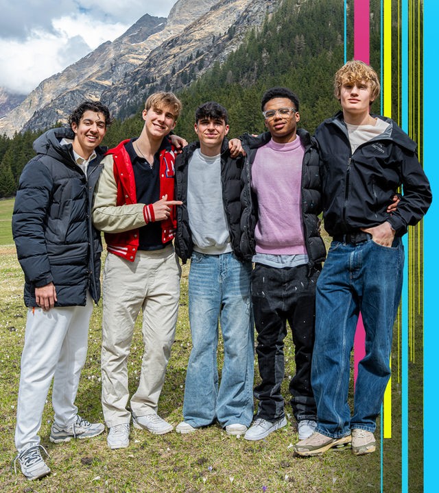 Lorian, Luke, Nick, Azad und Cay stehen auf einer Wiese - im Hintergrund die Berge