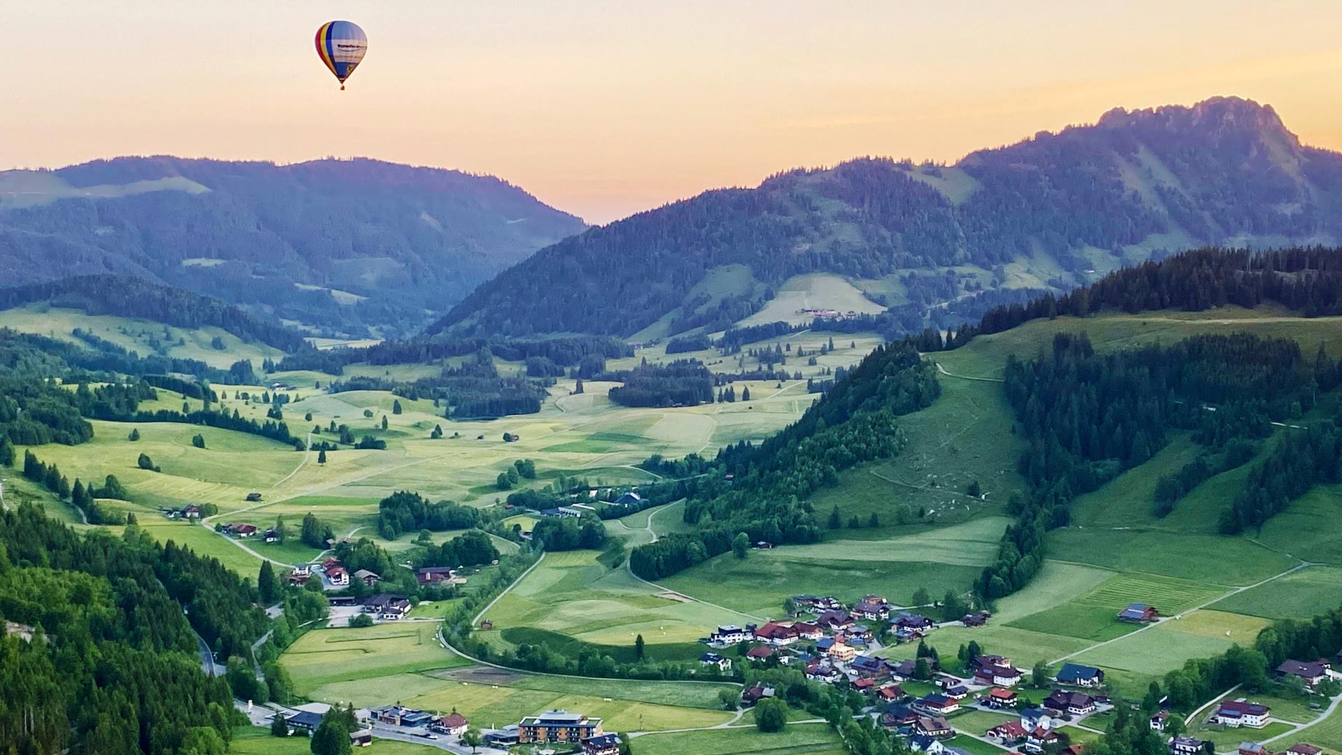 Heißluftballon über dem abendlichen Tannheimer Tal in Tirol