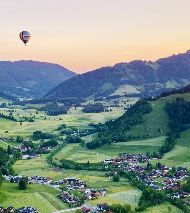 Heißluftballon über dem abendlichen Tannheimer Tal in Tirol