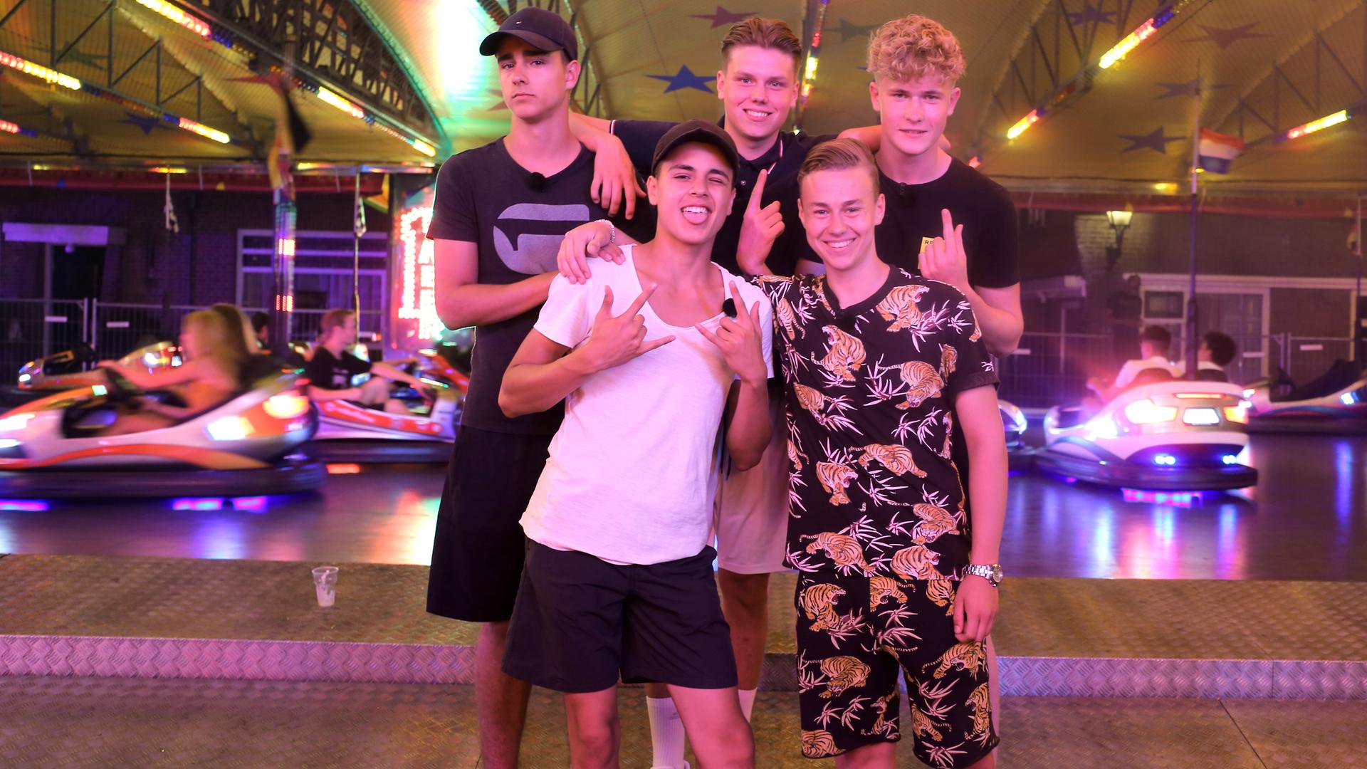 Luke, Ruben, Jeppe, Alex und Mark stehen vor einem Autoscooter