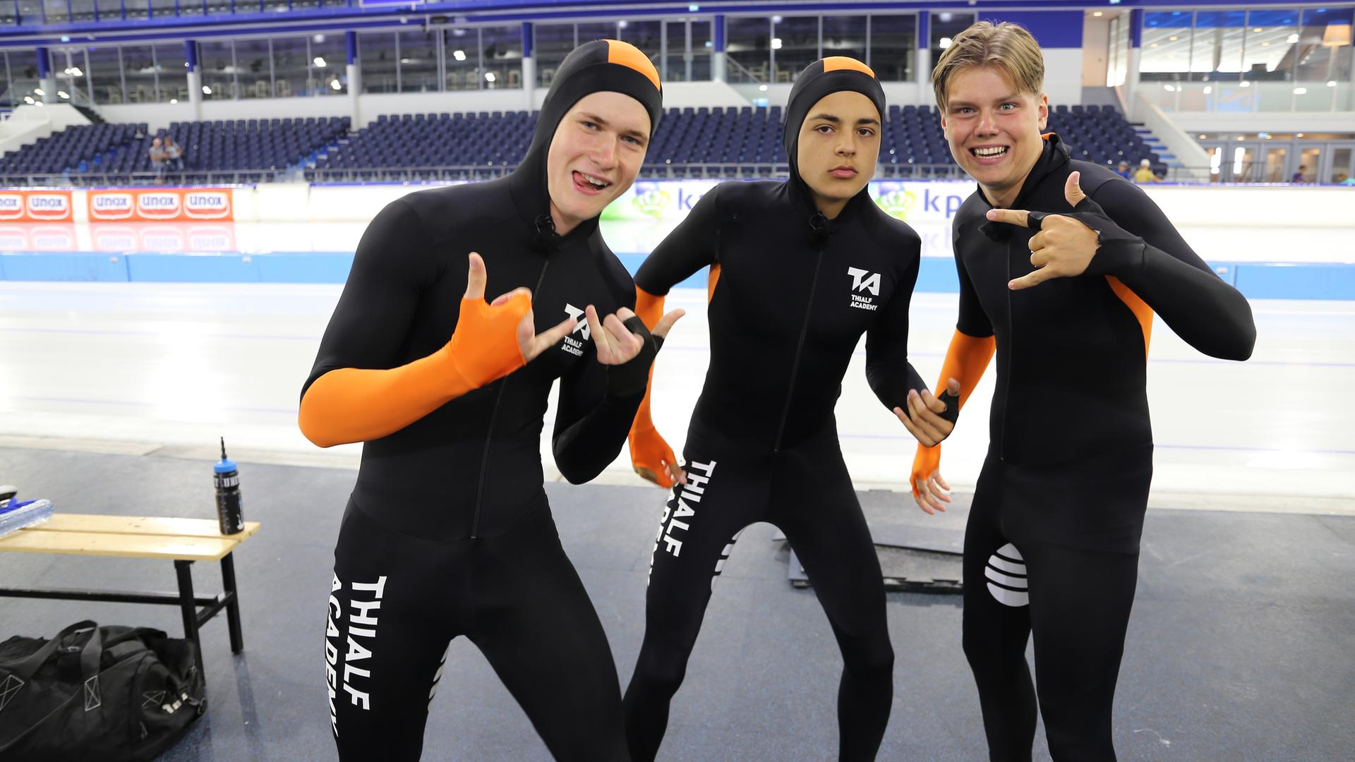 Mark, Ruben und Jeppe tragen enganliegende Anzügen, sie stehen vor einer Eisbahn