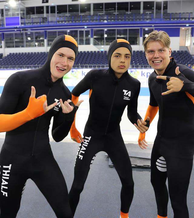 Mark, Ruben und Jeppe tragen enganliegende Anzügen, sie stehen vor einer Eisbahn