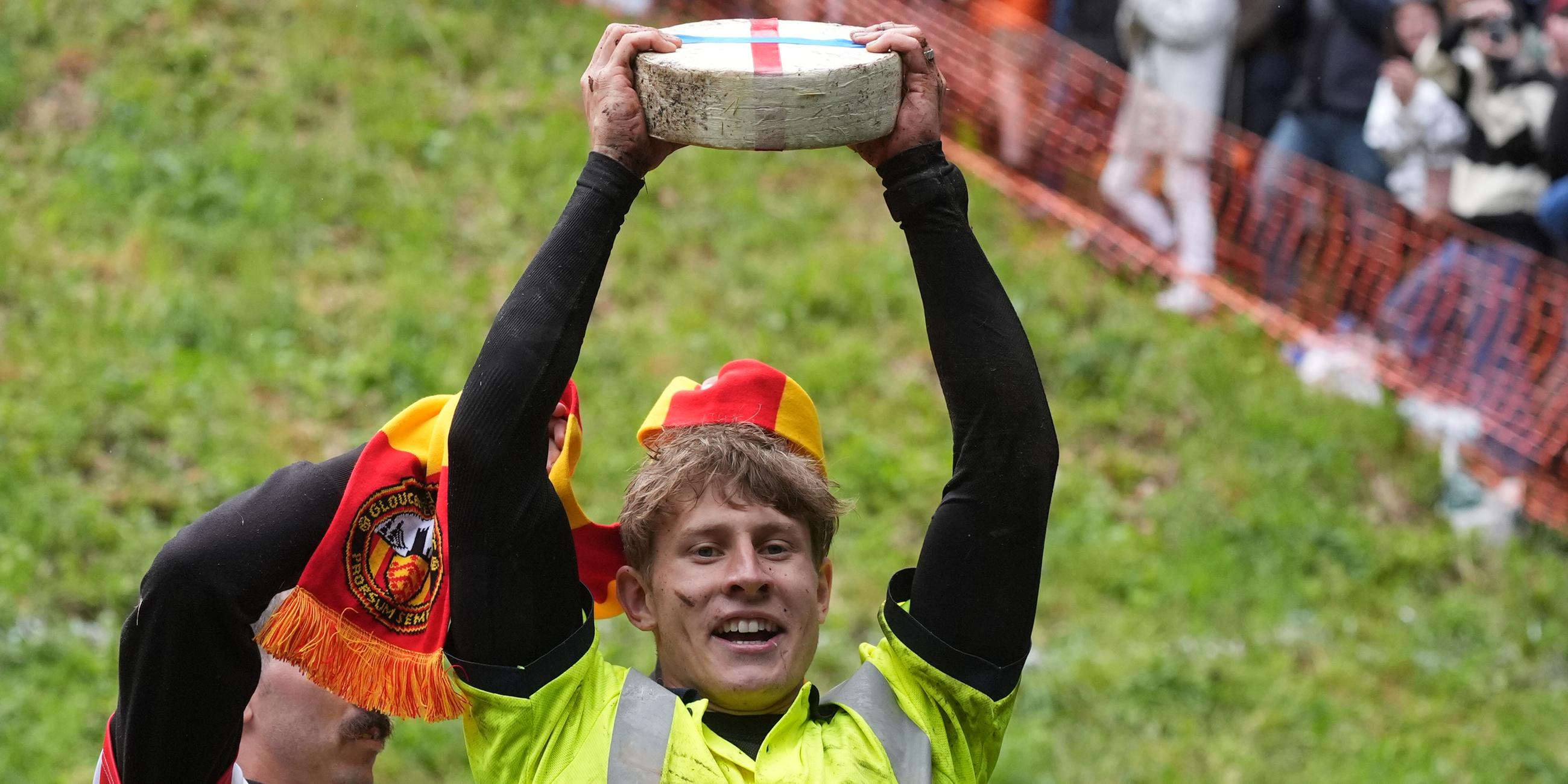 Tom Kopke, der 22-Jährige Münchner, hebt einen Double-Gloucester-Käse, nachdem er das traditionelle Käserennen gewonnen hat.
