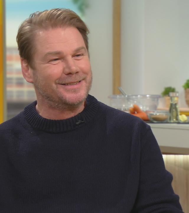 Schauspieler Kai Scheve sitzt im Volle-Kanne-Studio und lacht.