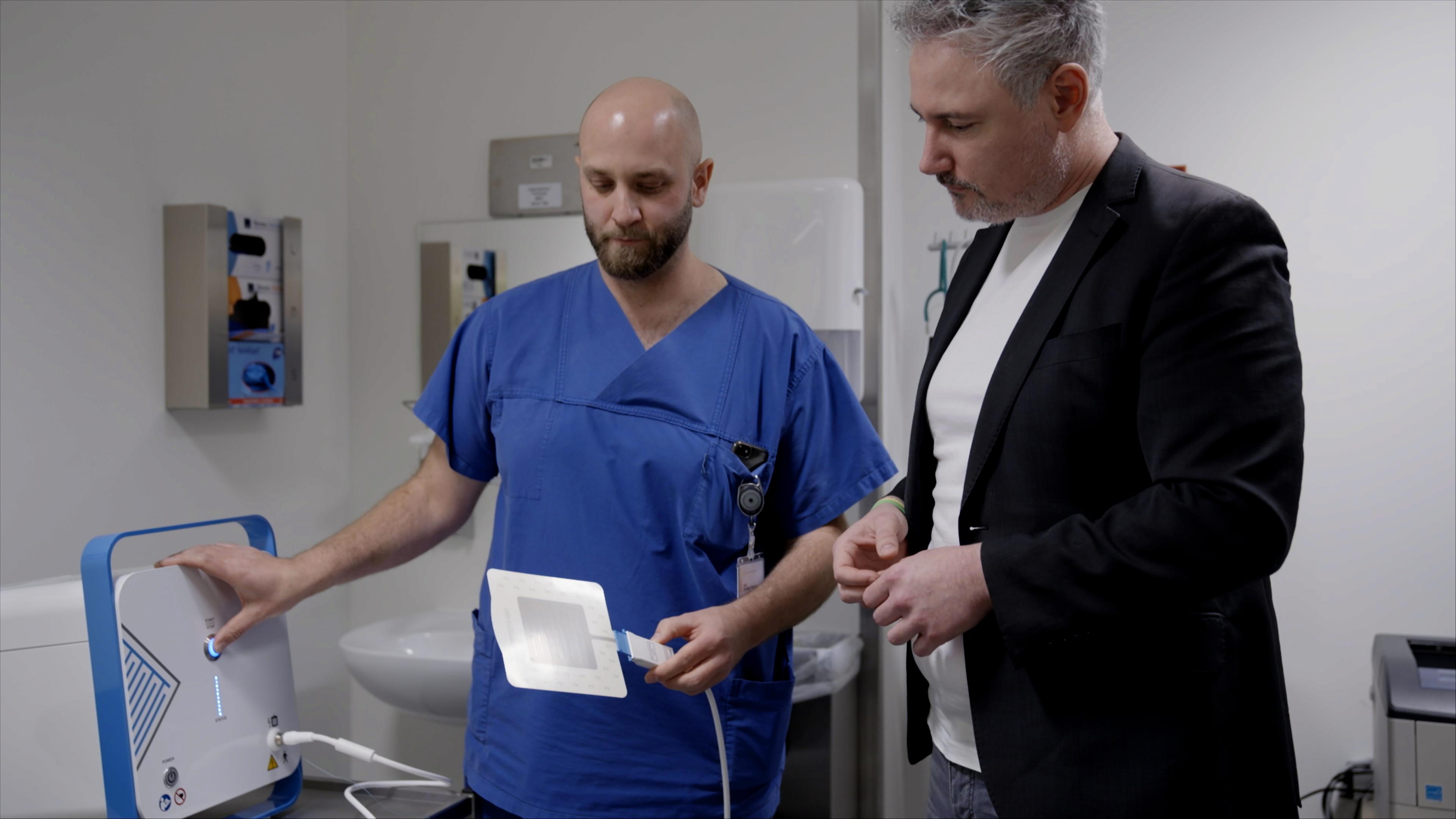 Ein Arzt vom Städtischen Klikikum Karlsruhe zeigt einem Interessenten die Kaltplasmatherapie.