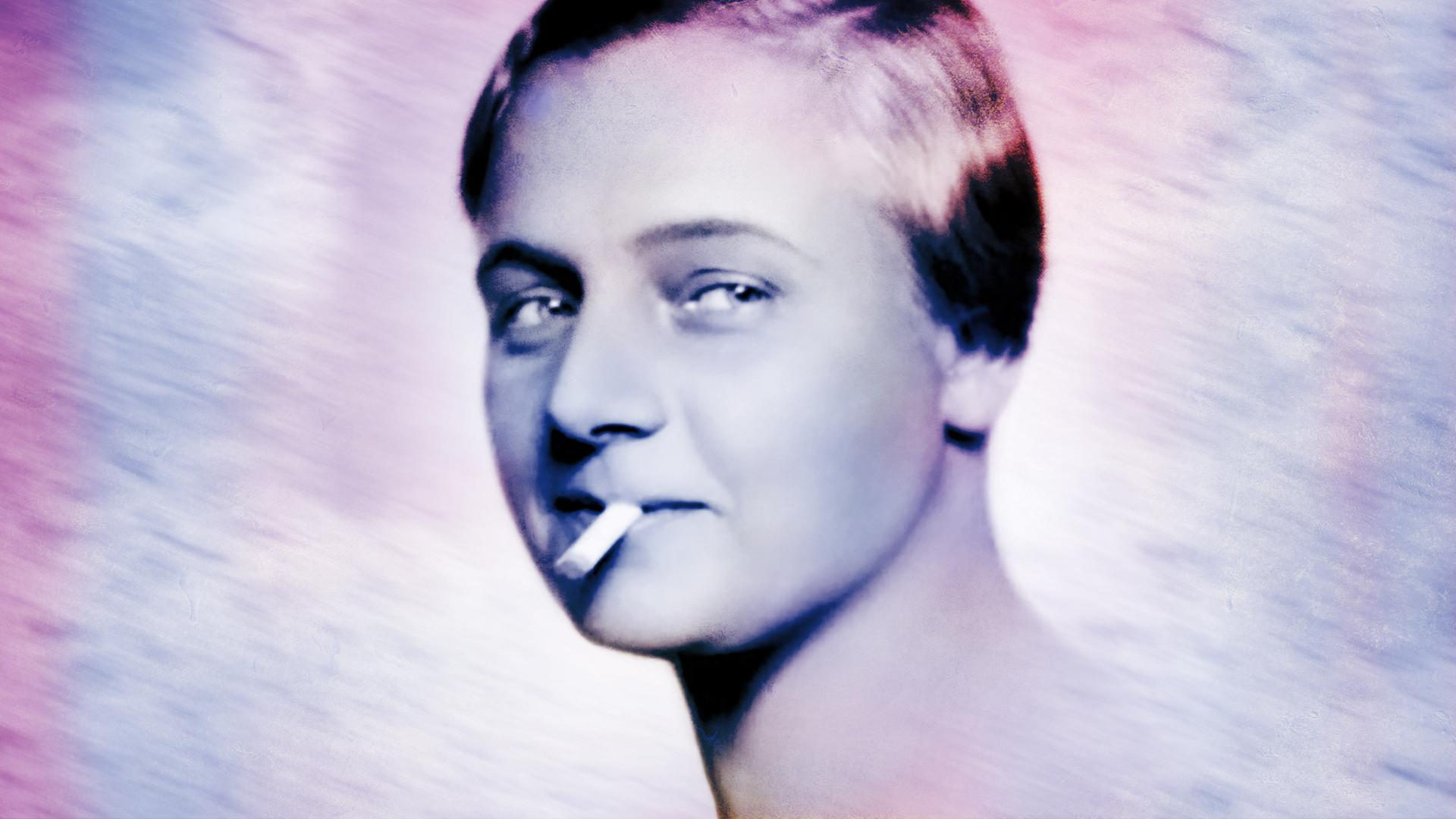 Das Bild zeigt eine schwarz-weiße Fotografie einer Frau, die mit einem selbstbewussten Ausdruck in die Kamera blickt. Sie hat kurzes, glattes Haar, das zur Seite gestylt ist. Zwischen ihren Lippen hält sie eine Zigarette. Der Hintergrund ist hell und unscharf, wodurch der Fokus auf ihrem Gesicht liegt. Die Frau hat eine leichte Lächeln, das eine gewisse Nonchalance ausstrahlt. Die Beschreibung bezieht sich auf die Person im Kontext des Films „Kampf der Frauen – Anfänge der Frauenbewegung in Österreich“, der sich mit der Geschichte der Frauenbewegung zur Jahrhundertwende beschäftigt.