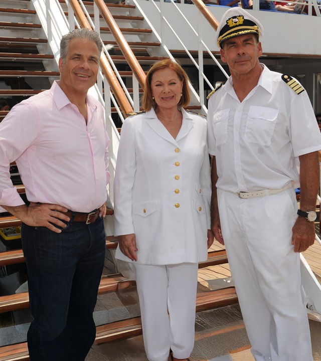 "Das Traumschiff: Kanada": Zusammen mit Peter Rand (Karsten Speck) und Beatrice (Heide Keller) steht Kapitän Burger (Sascha Hehn) an Deck des Schiffs. Sie lächeln in die Kamera.