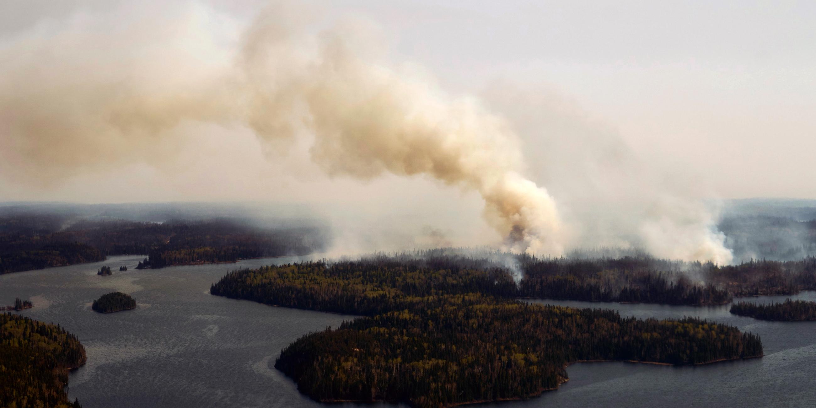 14.05.2024, Kanada, Flin Flon: Ein Waldbrand brennt im Norden Manitobas in der Nähe von Flin Flon, von einem Hubschrauber aus gesehen, der die Situation überwacht.