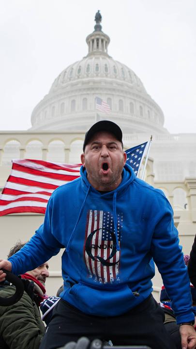 Trump-Anhänger vor dem Kapitol mit QAnon-Pullover.
