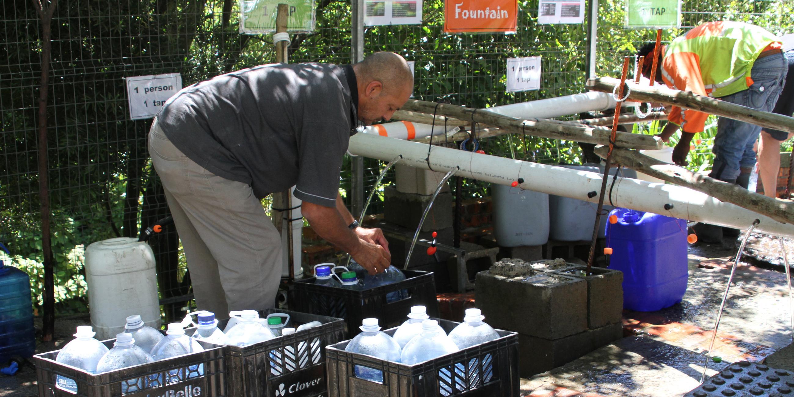Bürger füllen Wasserkanister an einer natürlichen Quelle in Newlands, Kapstadt