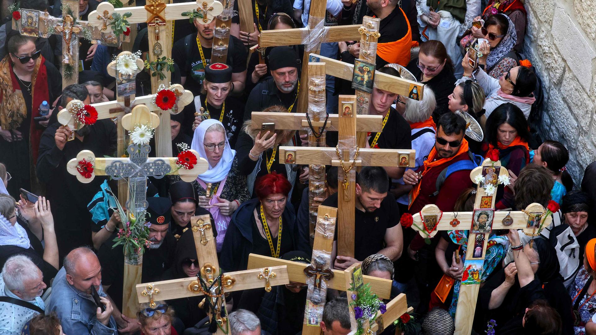 Chrisians carrying crosses walk through Jerusalem's Old City on their way to the Holy Sepulcre church during the Orthodox Good Friday procession.