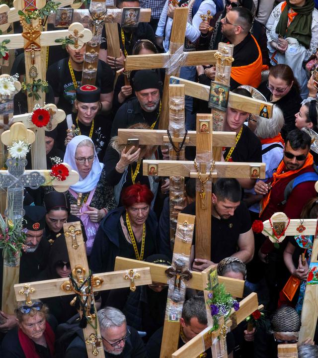 Chrisians carrying crosses walk through Jerusalem's Old City on their way to the Holy Sepulcre church during the Orthodox Good Friday procession.