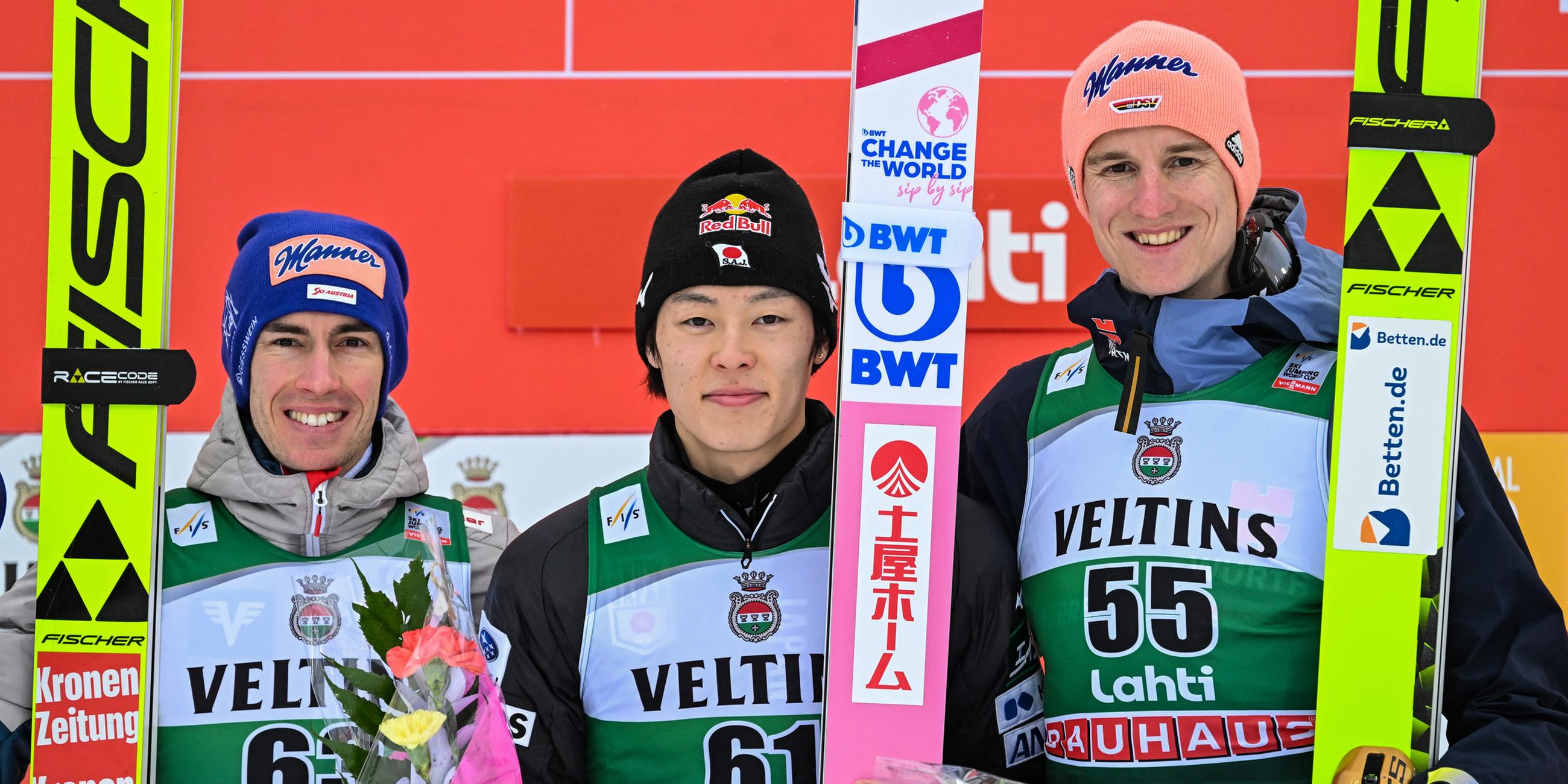 Stefan Kraft (Österreich, li.), Sieger Ryoyu Kobayashi (Japan, mi.) und drittplatzierter Karl Geiger (Deutschland, re.) feiern die Platzierung auf dem Podium.