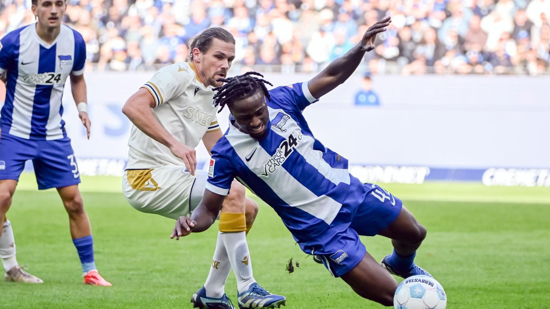 Der Karlsruher Sebastian Jung (l) und der Berliner Deyovaisio Zeefuik kämpfen um den Ball. 