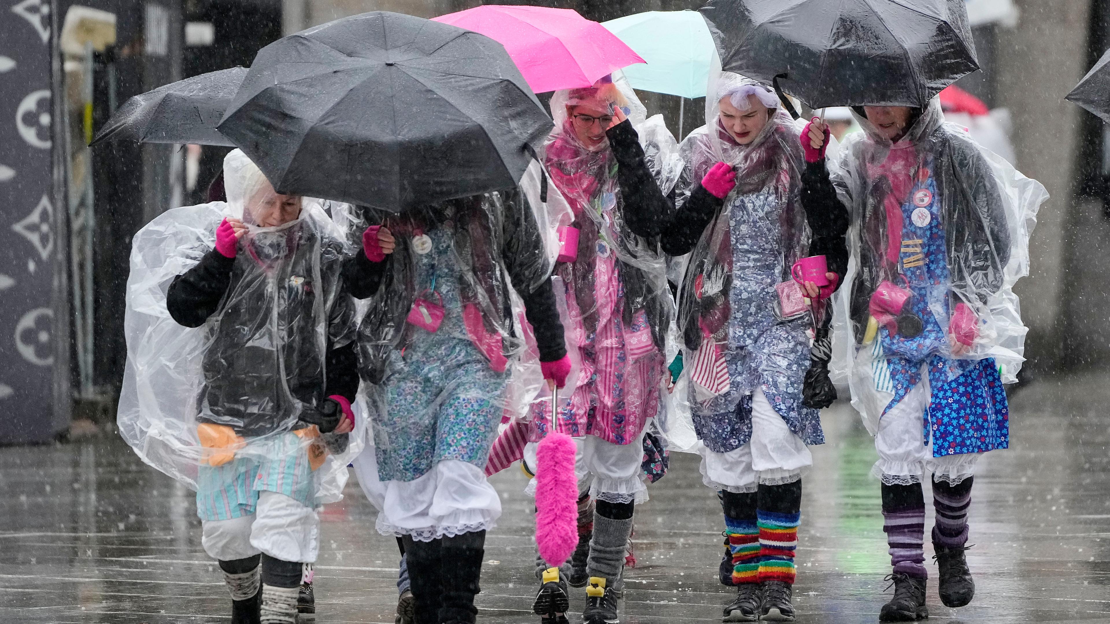 Köln: Verkleidete Menschen mit Regenschirmen vor dem Start des Köllner Straßenkarnevals 