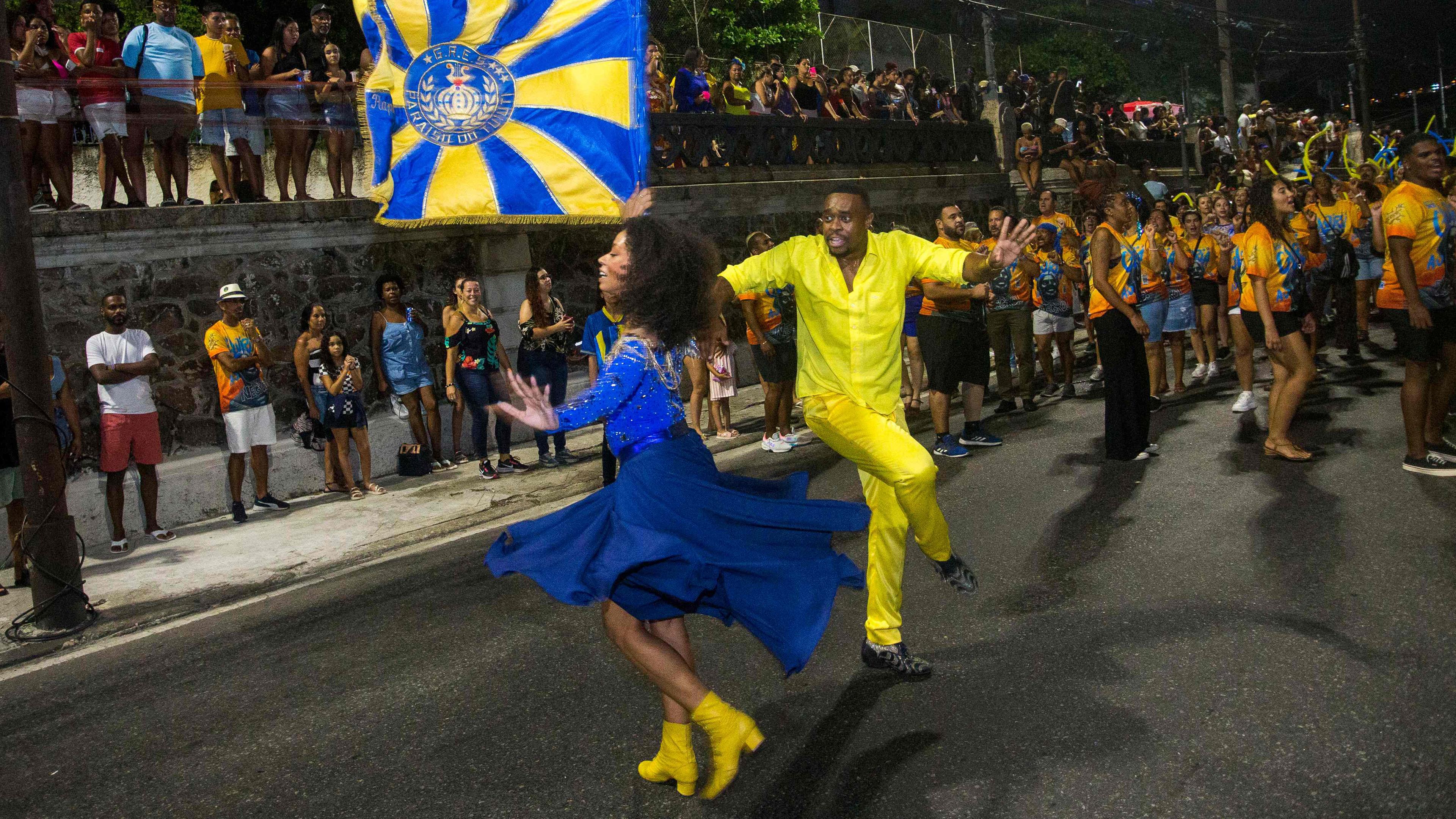 Raphael Rodrigues (r.) und Dandara Ventapane, Fahnenträger der Sambaschule Paraiso do Tuiuti, treten während einer Straßenprobe vor der traditionellen Karnevalsparade 2024 in Rio de Janeiro