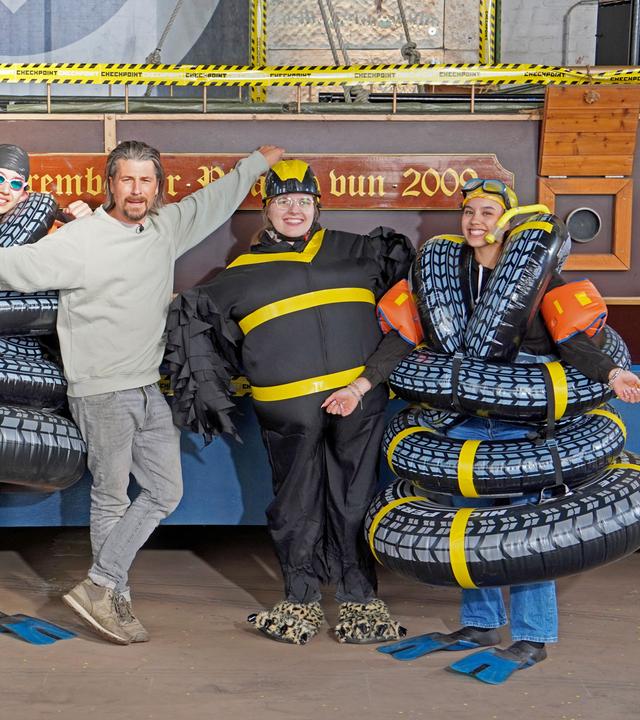 Checkpoint: Vier Mitglieder des Checkpoint-Teams stehen in selbstgemachten Kostümen gemeinsam mit Tommy Scheel in der Checkpoint-Halle. 