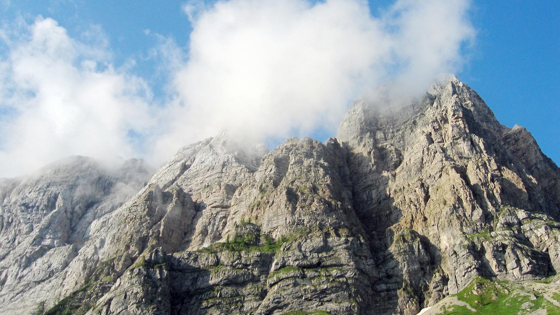 Wolken umgeben die Spitze einer Gebirgswand