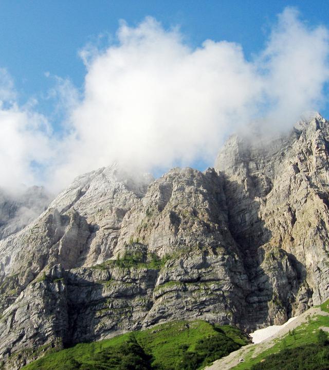 Wolken umgeben die Spitze einer Gebirgswand