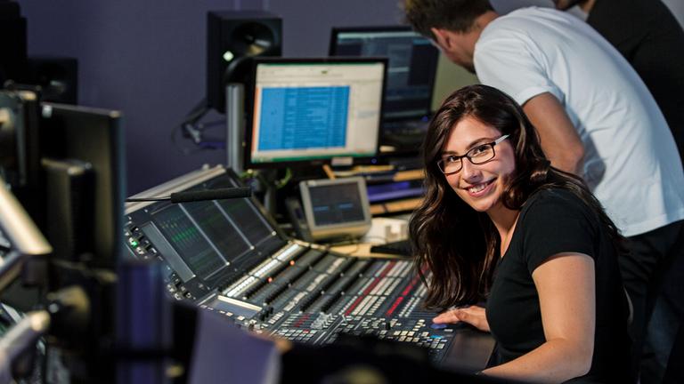 Typical ZDF-Ausbildung Veranstaltungtechnikerin: junge Frau am Mischpult