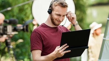 Typical ZDF-Ausbildung AV-Kaufleute: junger Mann mit Kopfhörer