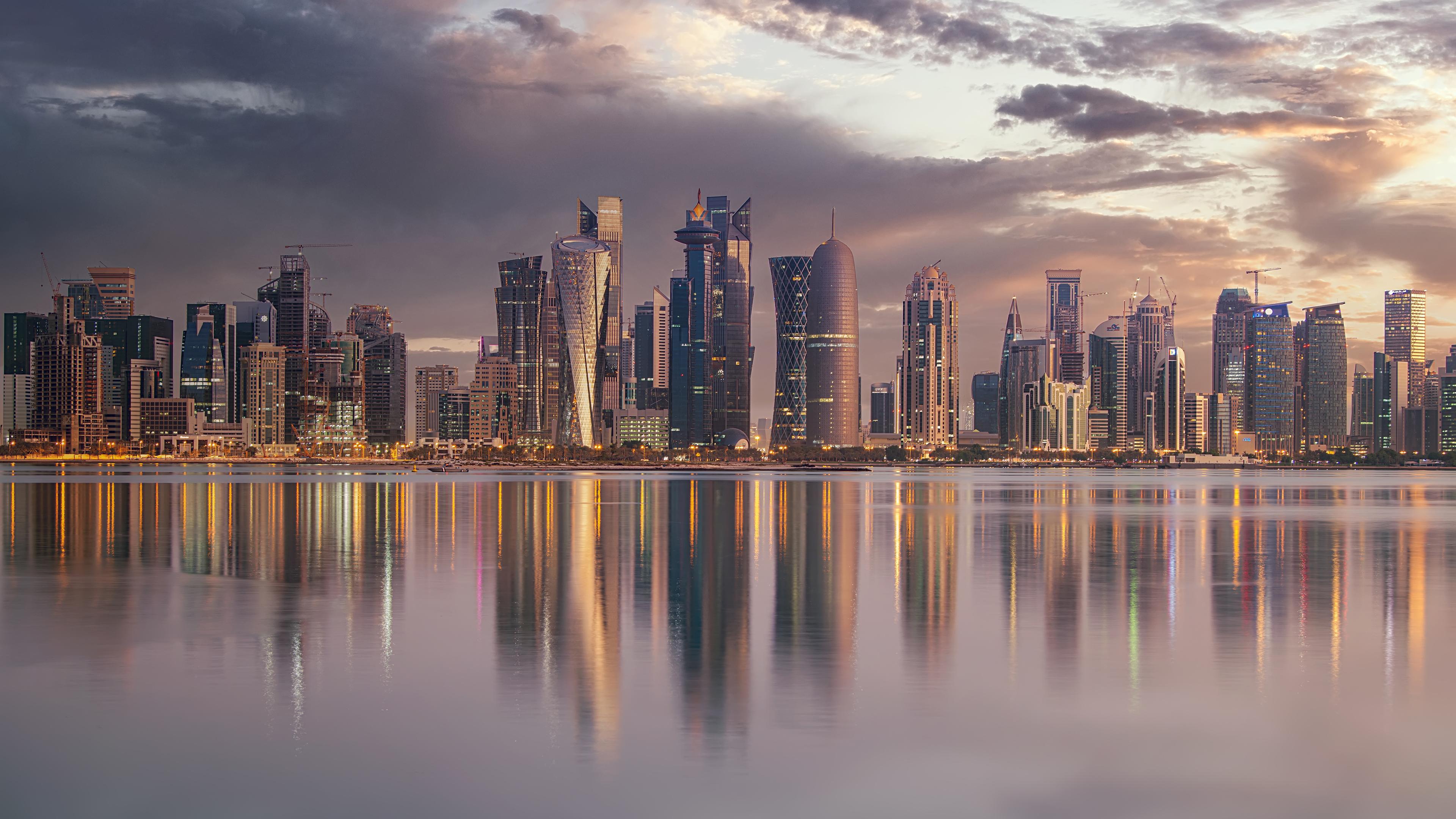 Küstenlandschaft Katars. Im Hintergrund sind viele gläserne Hochhäuser zu sehen, direkt an der Küste.