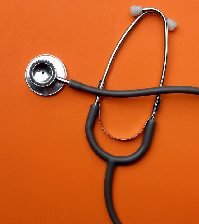 Auf dem Bild ist ein Stethoskop vor orangenem Grund zu sehen.