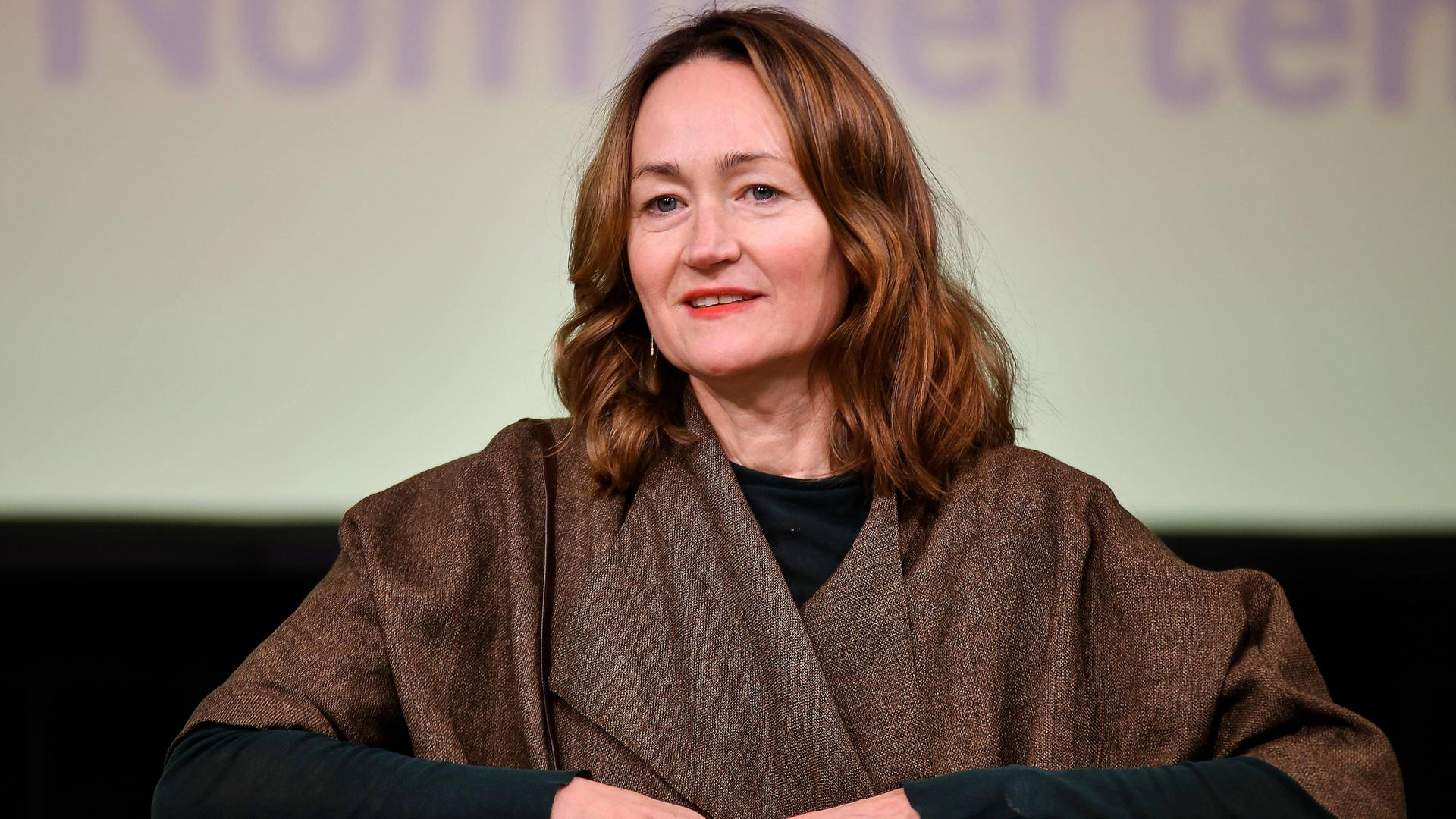 Porträtfoto einer Frau mittleren Alters mit langen rötlichen Haaren.