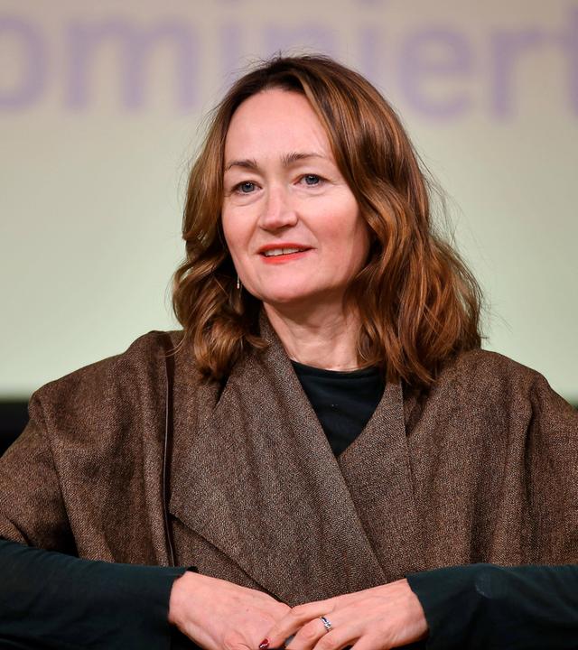 Porträtfoto einer Frau mittleren Alters mit langen rötlichen Haaren.