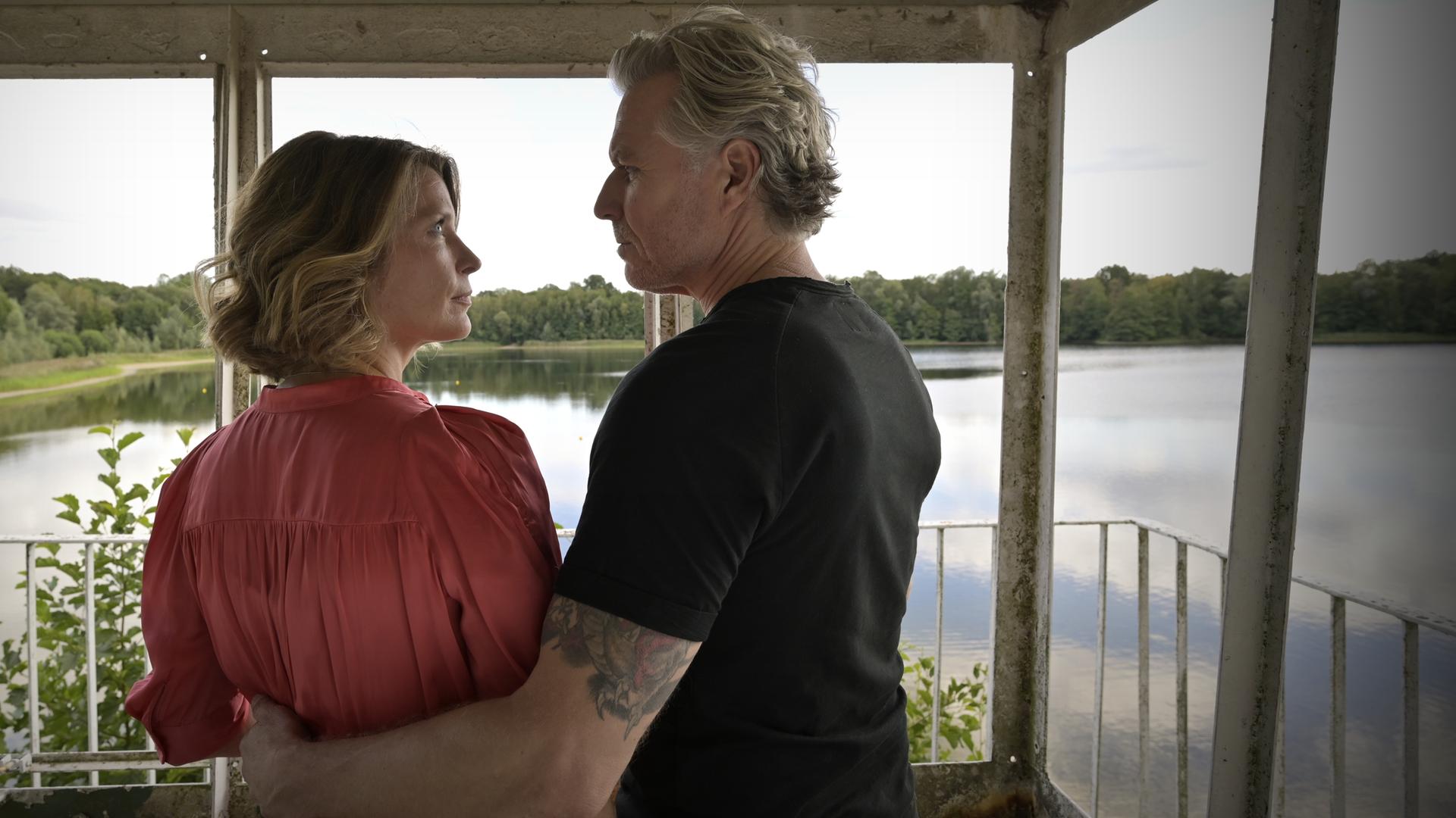 "Nächste Ausfahrt Glück - Katharinas Entscheidung": Katharina (Valerie Niehaus) und Juri (Dirk Borchardt) stehen nebeneinander auf einem Aussichtsturm und schauen sich an. Unter ihnen ist ein See mit begrüntem Ufer zu sehen.