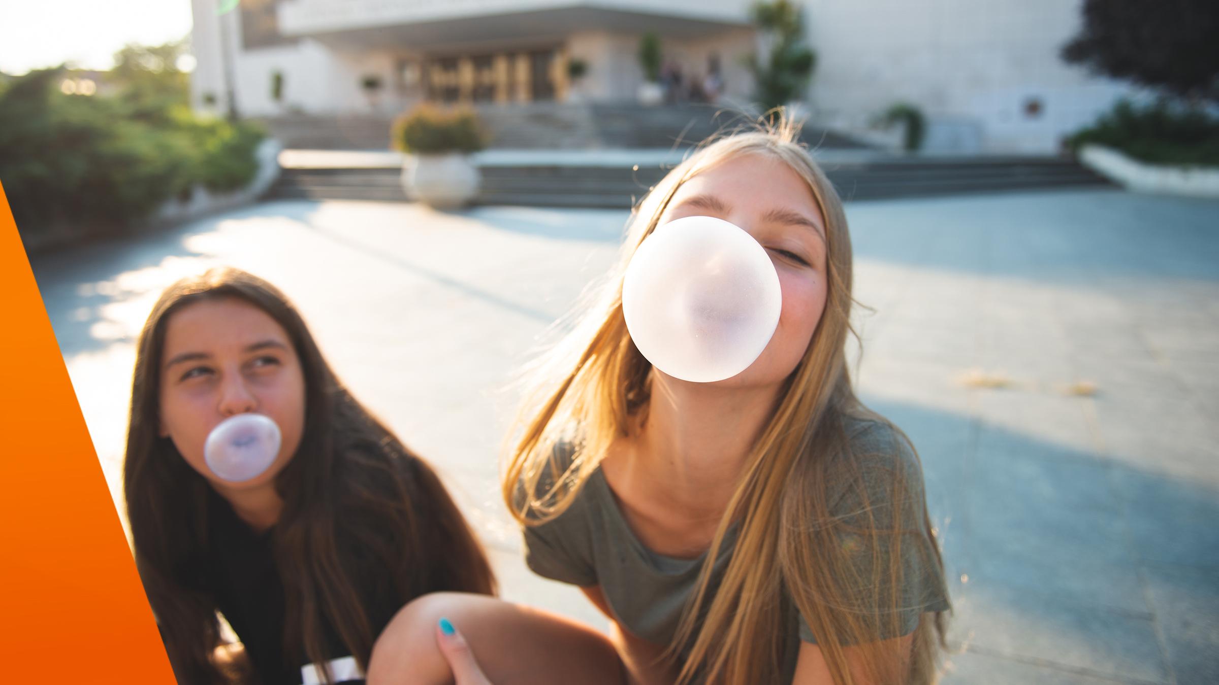 Zwei Mädchen machen Kaugummiblasen