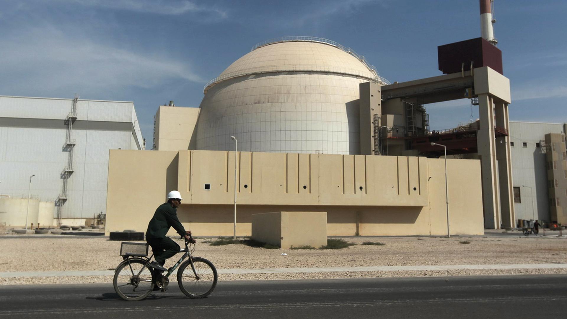 Archiv: Ein Arbeiter fährt mit dem Fahrrad vor dem Reaktorgebäude des Kernkraftwerks Bushehr, etwas außerhalb der südlichen Stadt Bushehr. (2010)