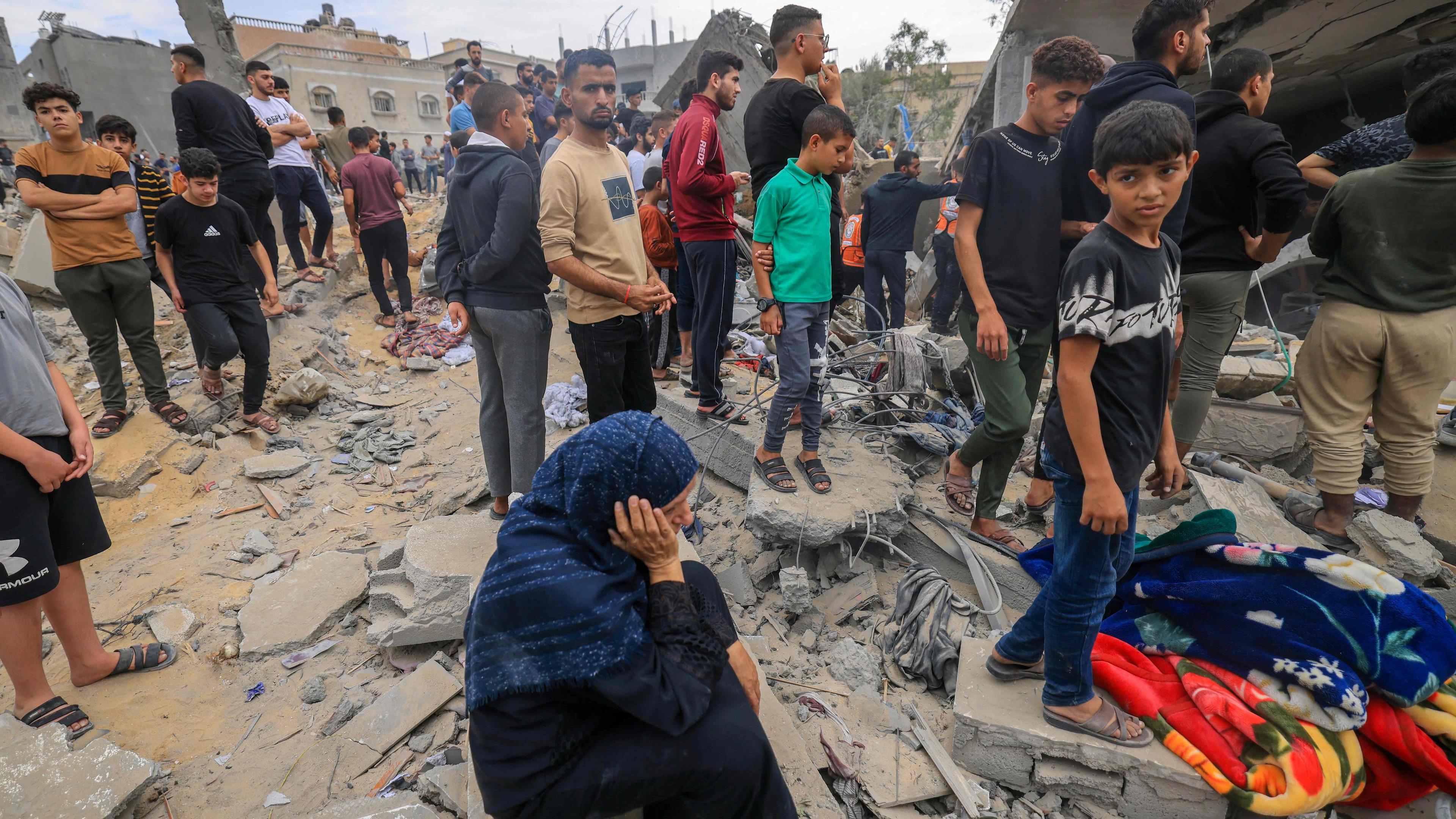Menschen stehen in den Trümmern eines Gebäudes in Khan Yunis nach israelischen Angriffen.