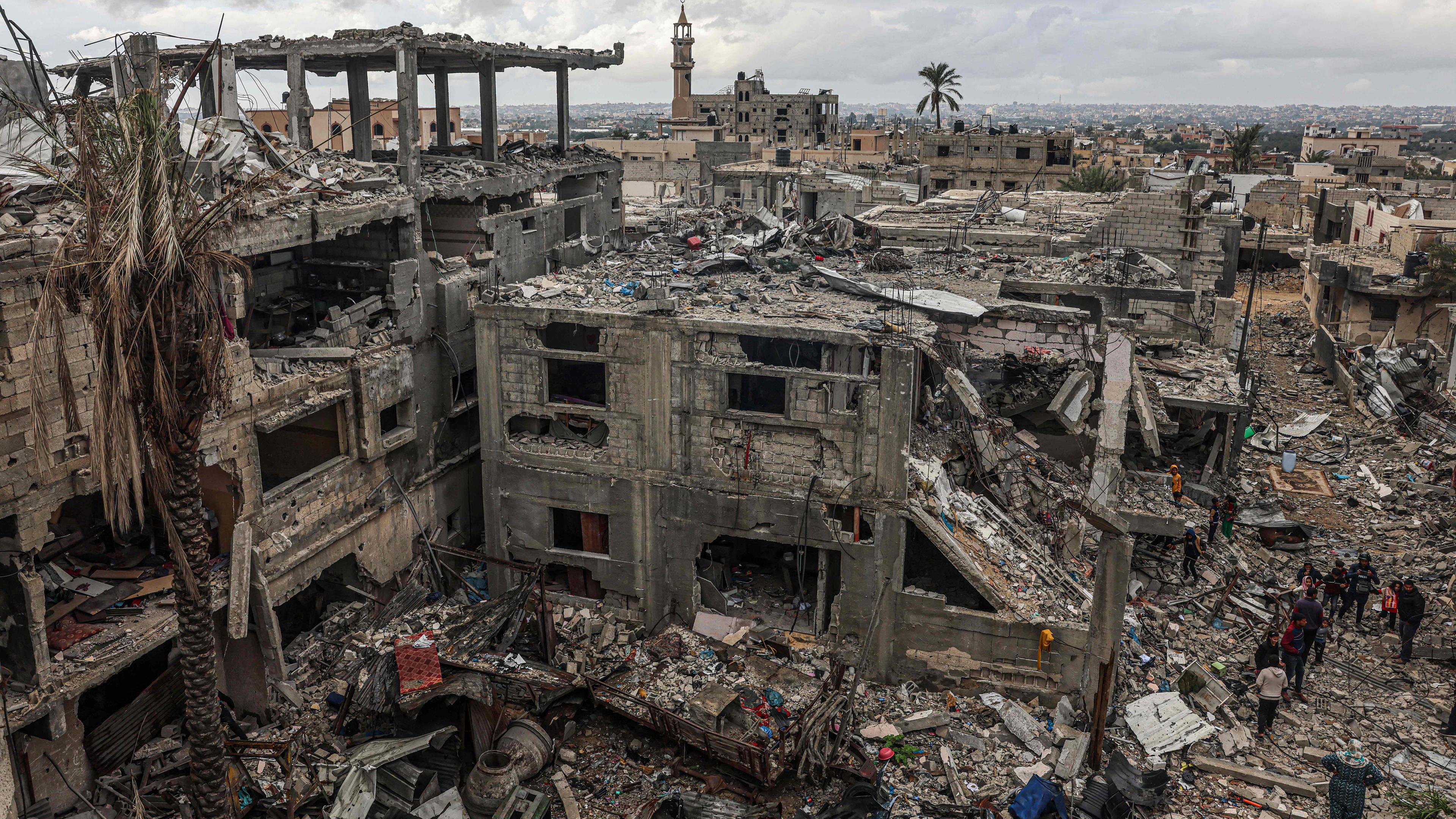Palästinenser inspizieren die Zerstörung, die durch israelische Angriffe auf ihre Häuser im Dorf Khuzaa östlich von Khan Yunis in der Nähe des Grenzzauns zwischen Israel und dem südlichen Gazastreifen am 27. November 2023 verursacht wurde