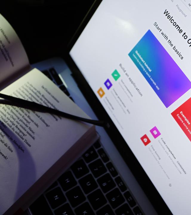 Ein Gedichtband liegt an einem Bildschirm auf dem die Homepage von ChatGPT aufgerufen ist