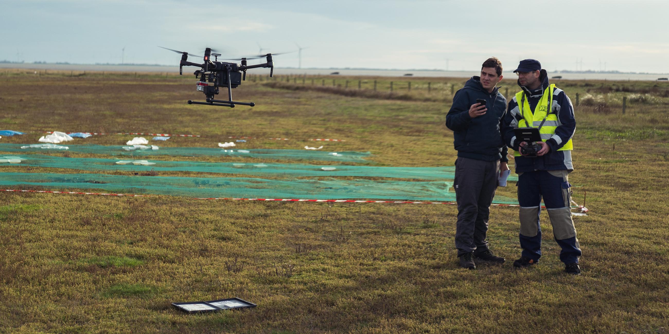 Ingenieur Michael Butter (r) und Wissenschaftler Mattis Wolf besprechen, in welche Höhen die Drohne den Feldversuch überfliegen wird.