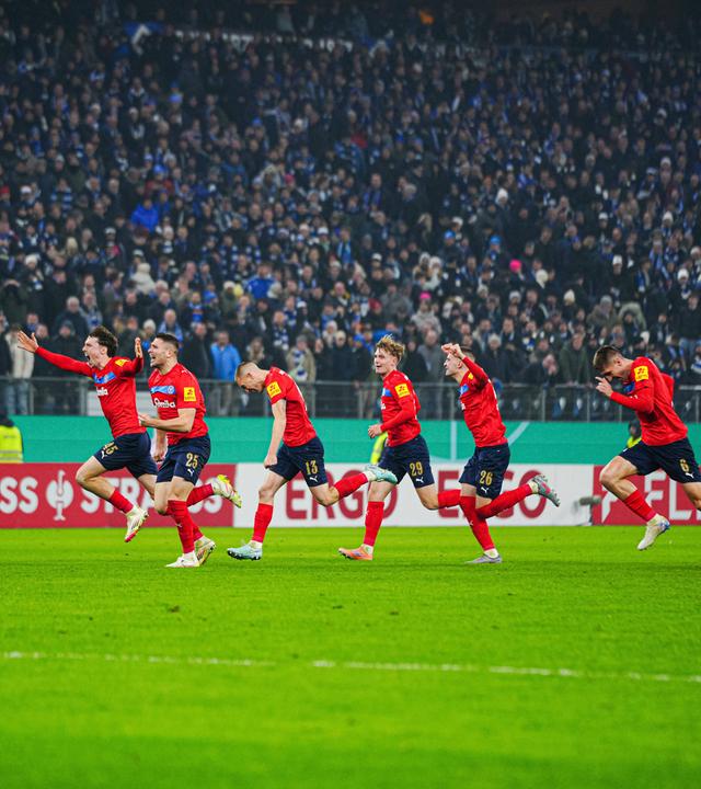 Die Spieler von Holstein Kiel rennen jubelnd zu ihrer Fankurve nach dem Sieg im Elfmeterschießen im DFB-Achtelfinale gegen den HSV