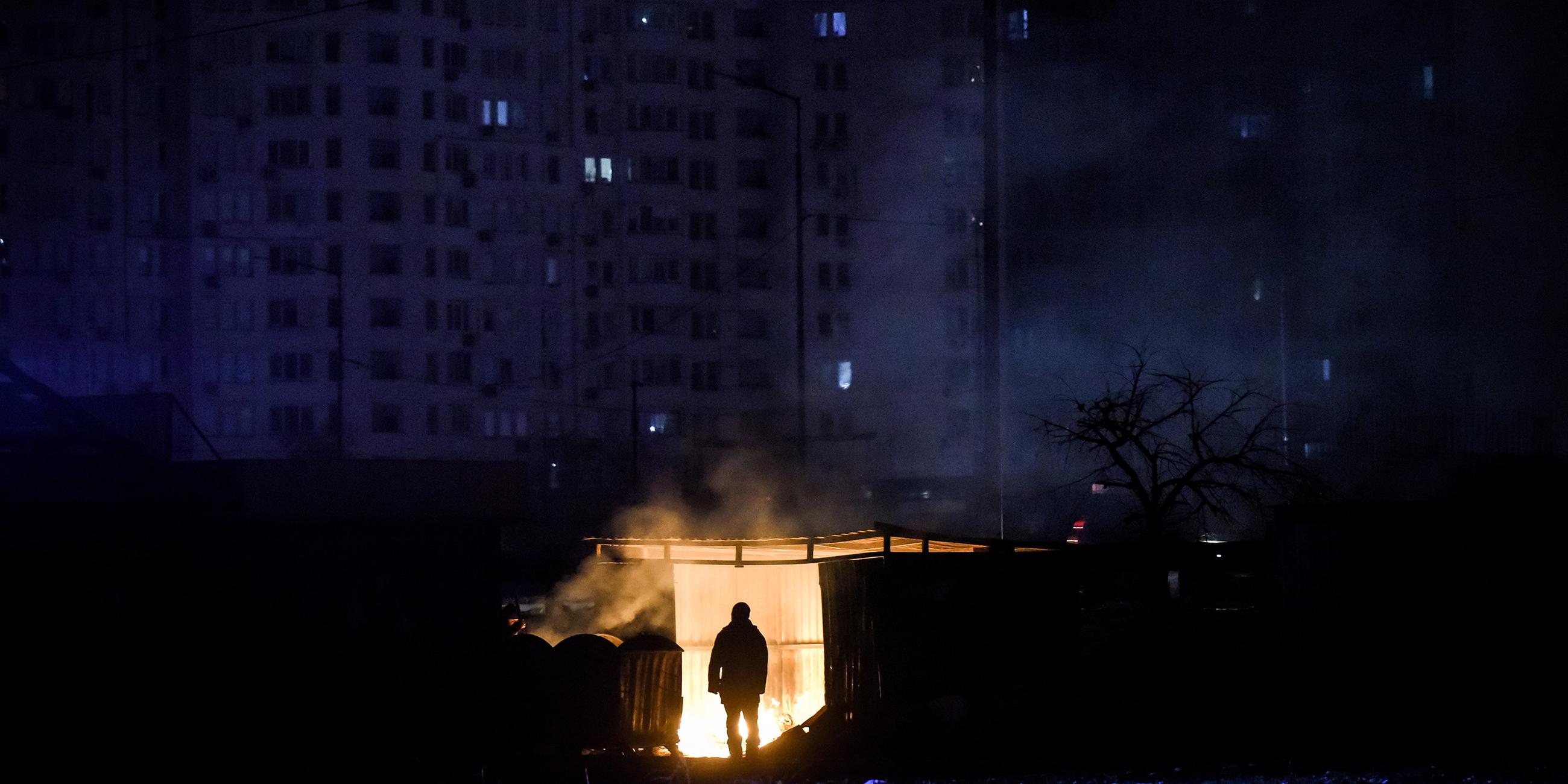 Ein Mann steht vor einer Garage vor einem Wohnhaus in Kiew