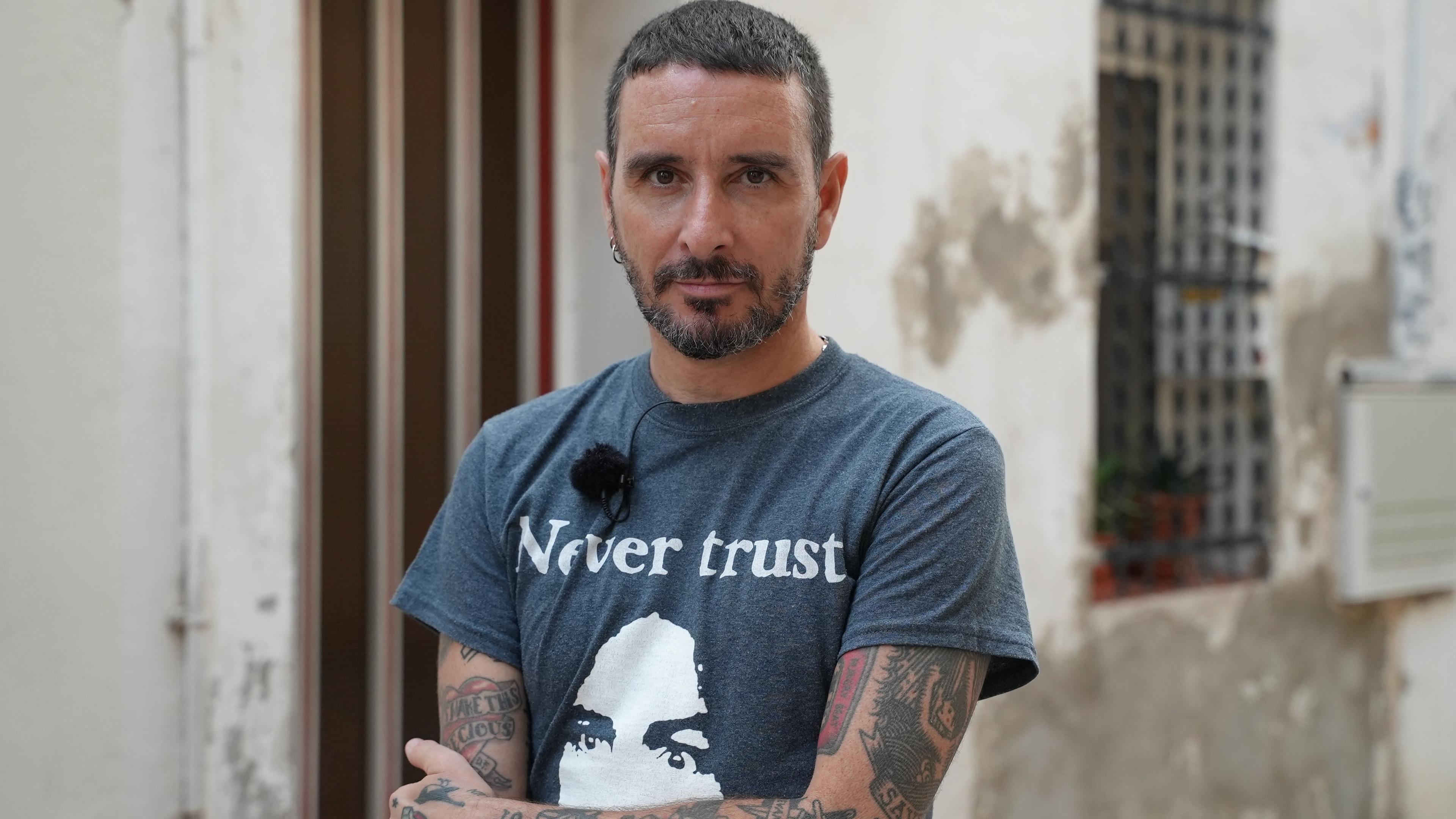 Mann mit verschränkten Armen und T-shirt auf dem zu lesen ist: Never trust.