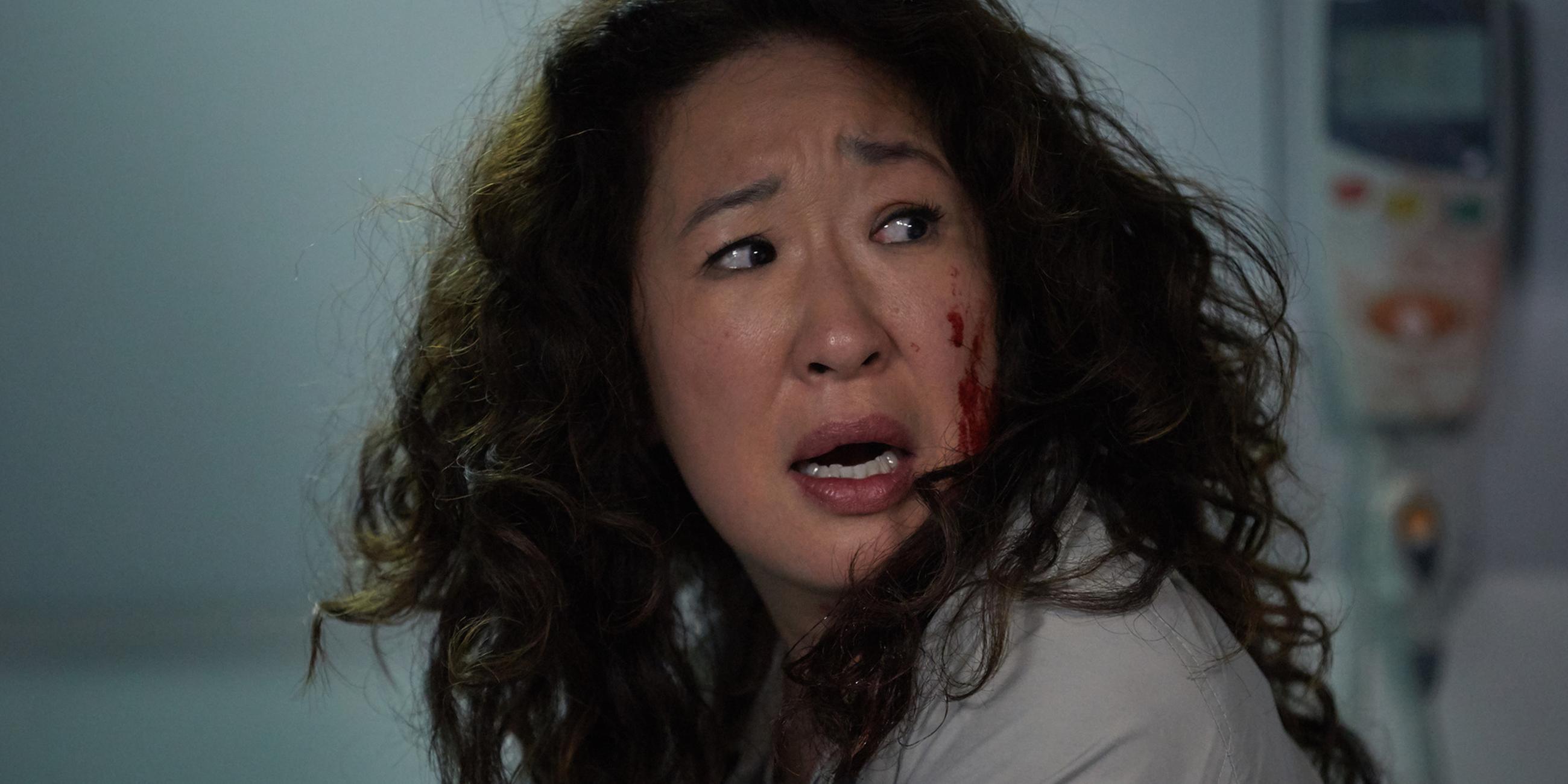 "Killing Eve – Nettes Gesicht": Eve (Sandra Oh) steht neben einem Krankenbett und schaut schockiert zur Seite. Dabei ist ihre Wange mit Blut beschmiert.