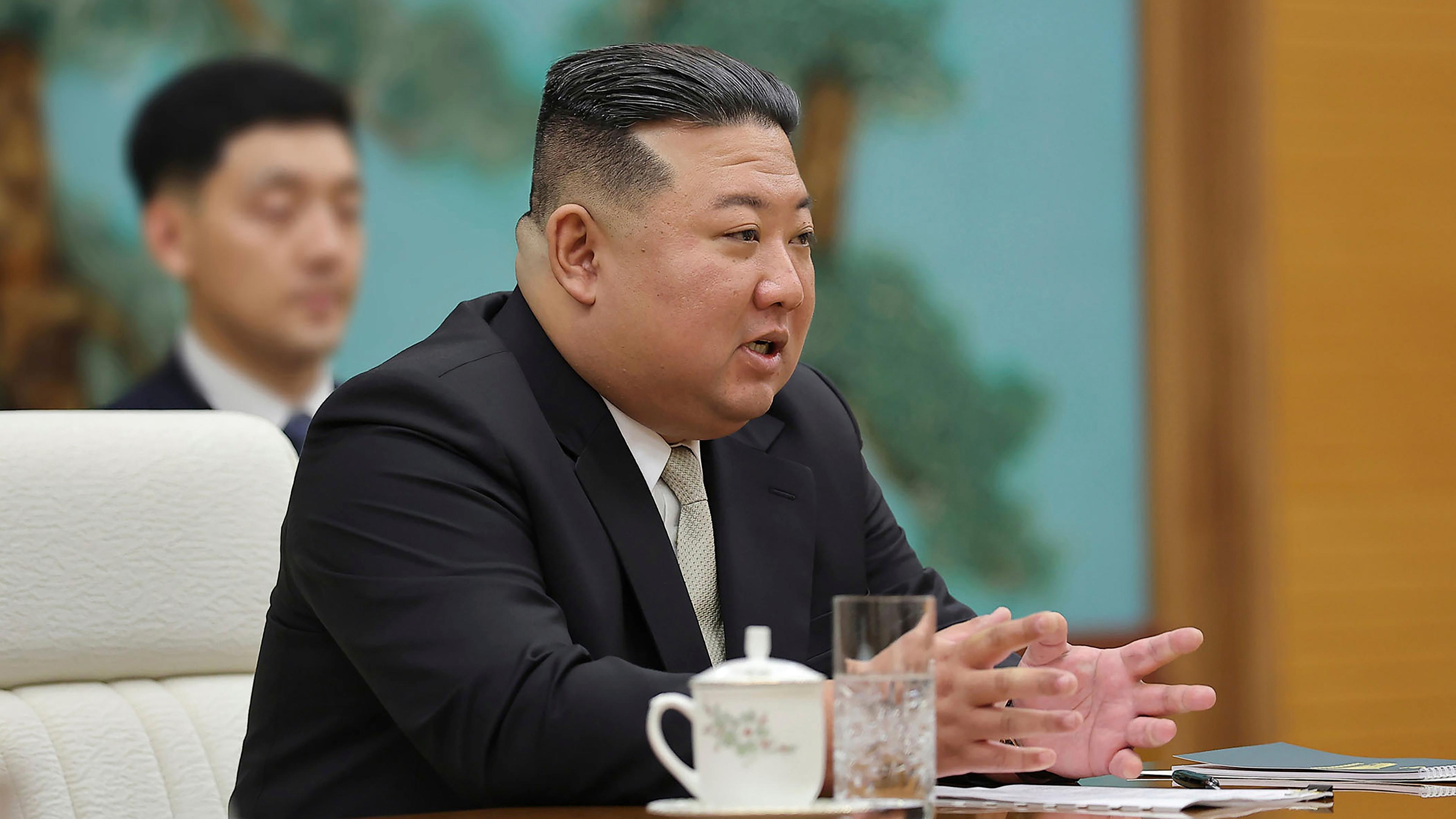 Kim Jong Un sitzt an einem Tisch und führt ein Gespräch 