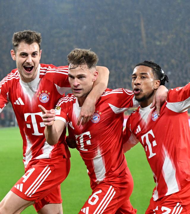 Bayerns Mittelfeldspieler Joshua Kimmich jubelt zusammen mit seinen Teamkollegen Josip Stanisic und Michael Olise nach seinem Tor zum 2:3 Endstand gegen den BVB
