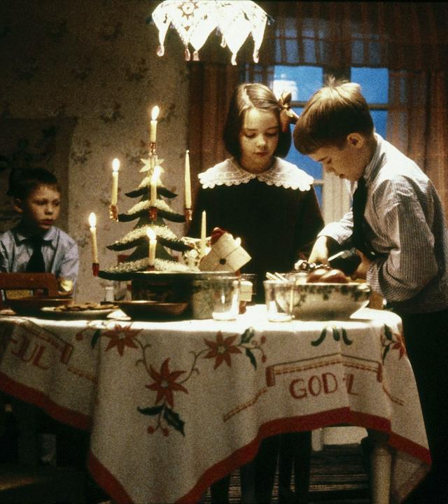 Bosse (Henrik Larsson, l.), Inga (Anna Sahlin, 2.v.l.), Lasse (Crispin Dickson Wendenius, 2.v.r.) und Ole (Harald Lönnbro, r.) feiern Weihnachten bei reich gedecktem Tisch.