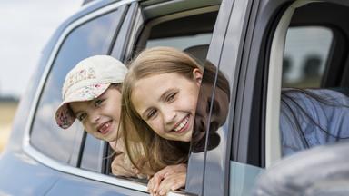 Zwei Mädchen schauen aus Autofenster
