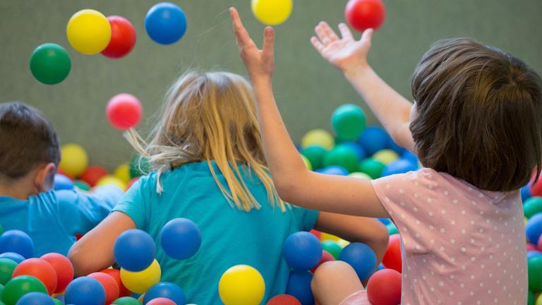 Kinder spielen in einem Bällebad in einer Kindertagesstätte 
