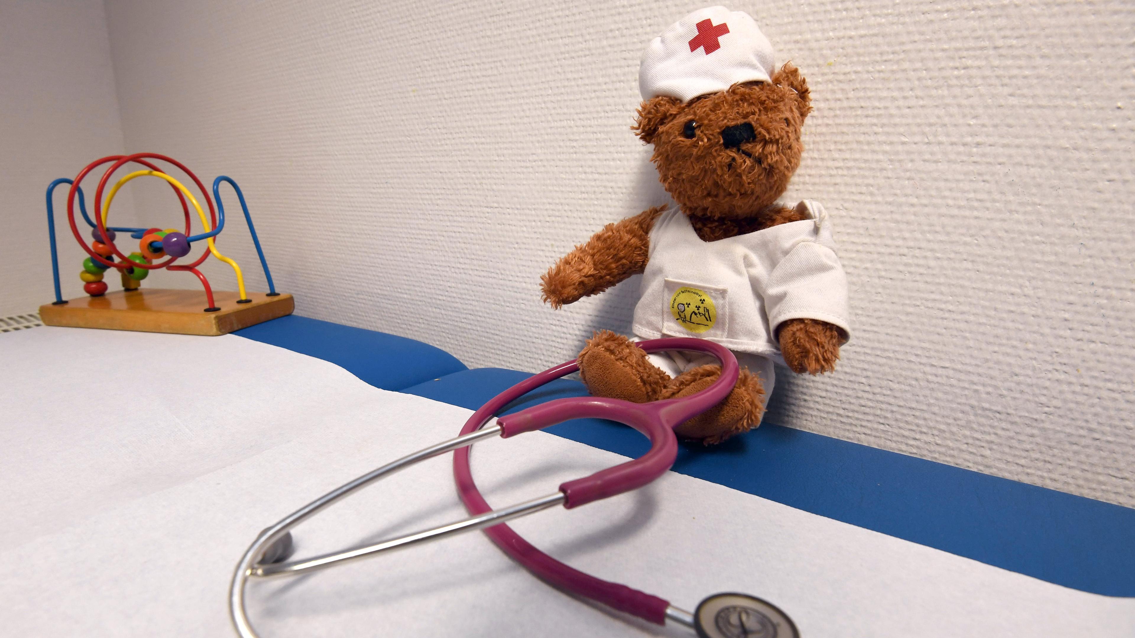 Ein Teddybär mit einem Stethoskop in einer Kinderarztpraxis.