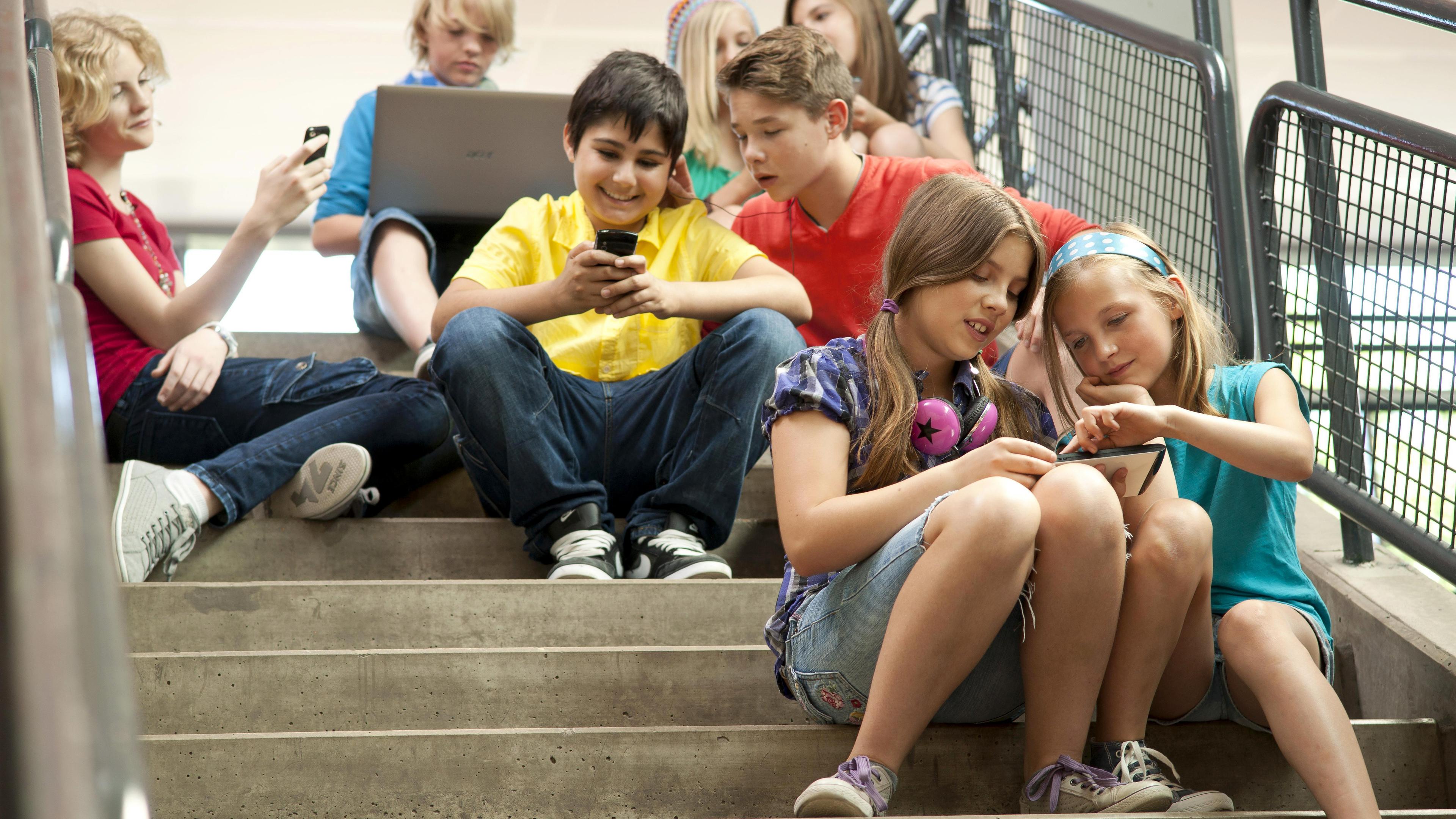 Archiv: Eine Gruppe Schüler sitzt auf einer Treppe und kommuniziert mit Tablet-PCs und Smartphones (undatierte Aufnahme)