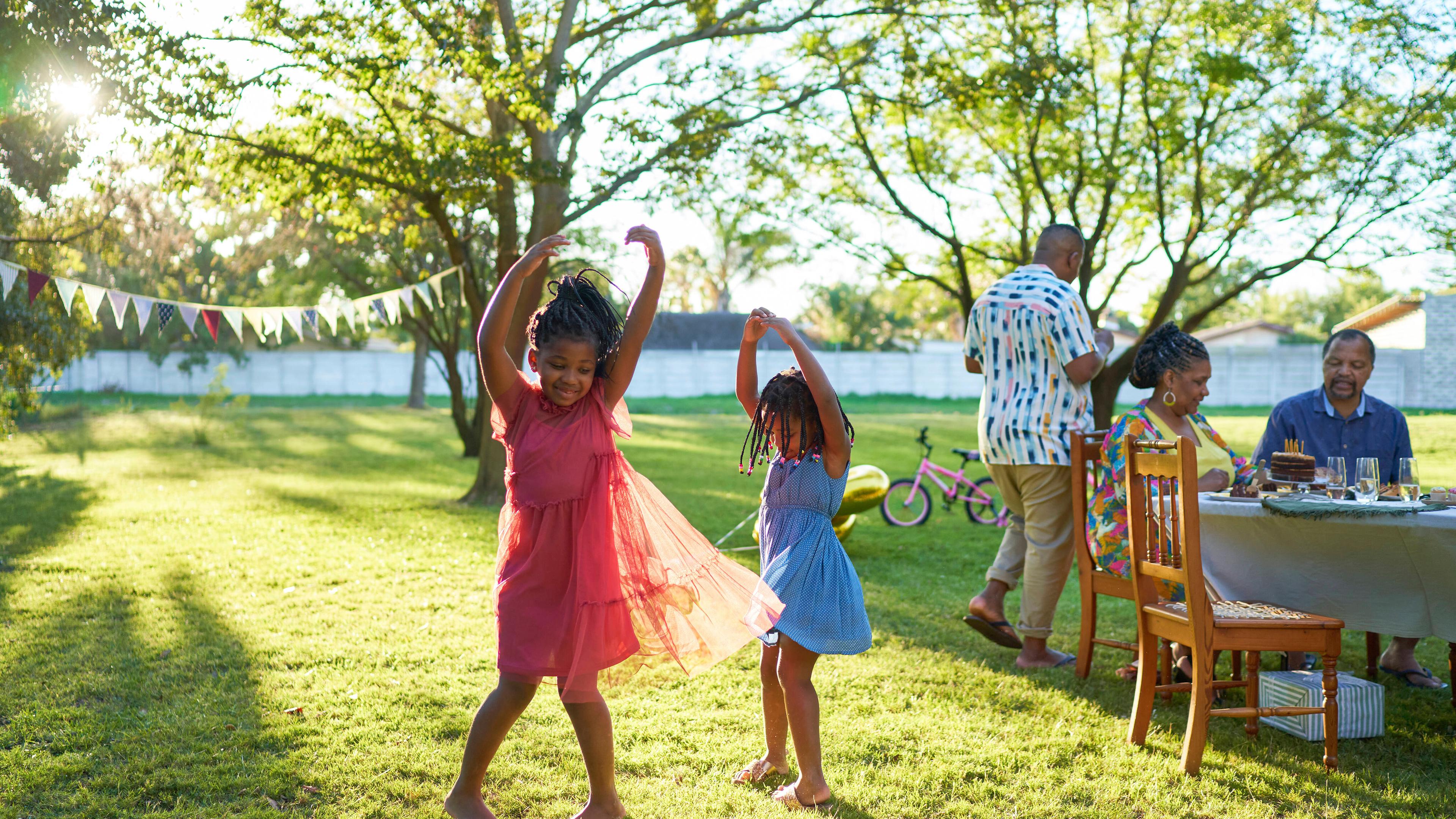 Zwei Mädchen tanzen auf Wiese